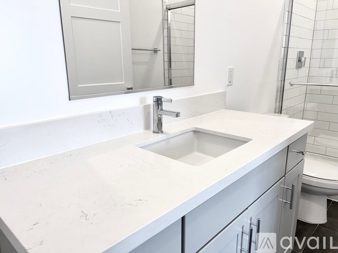 A white bathroom with a sink and mirror.