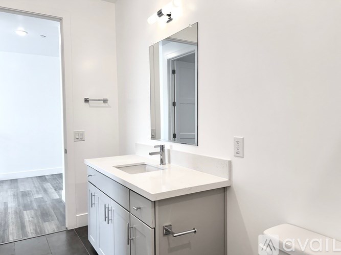 A bathroom with a sink, mirror, and cabinets.