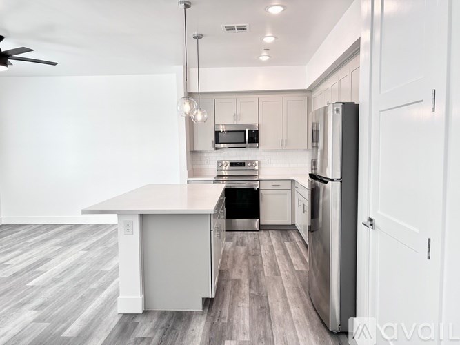 A kitchen with a white island and stainless steel appliances.