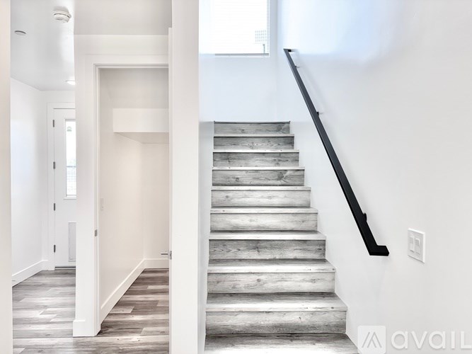 A staircase with a black handrail and wooden steps.