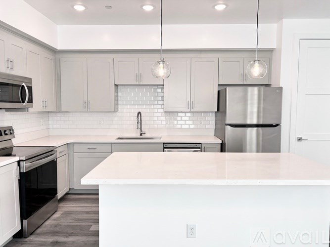 A modern kitchen with white appliances and cabinets.