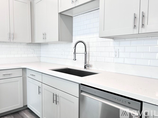A kitchen with white cabinets and a black sink.