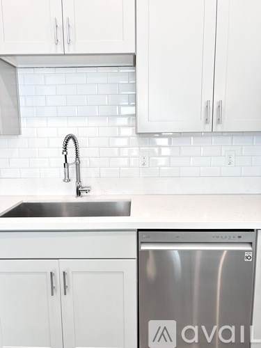 A kitchen with white cabinets and a stainless steel dishwasher.