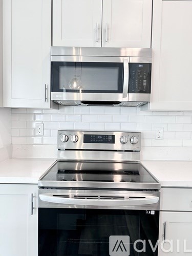 A modern kitchen with a stainless steel oven and microwave above it.