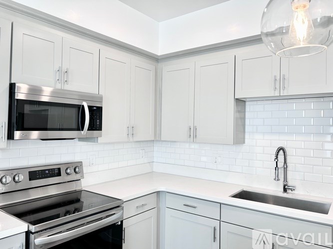 A kitchen with white cabinets and a stainless steel oven.