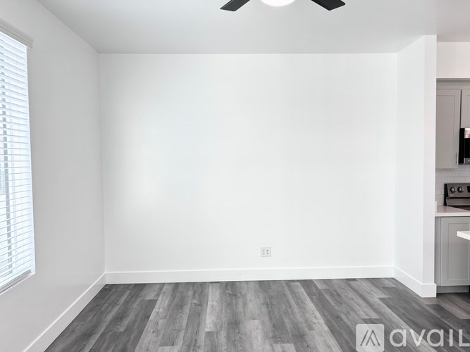 A room with a ceiling fan and a window with blinds.