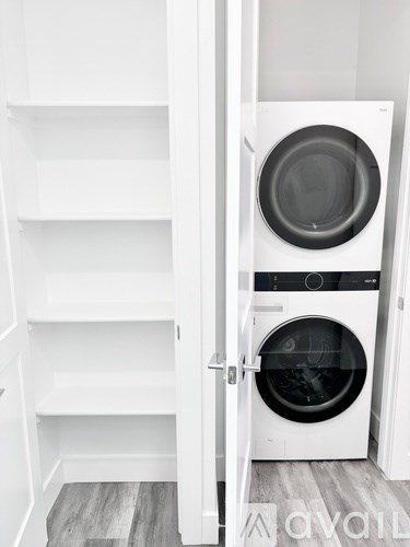A white door is open to a laundry room with a washer and dryer.