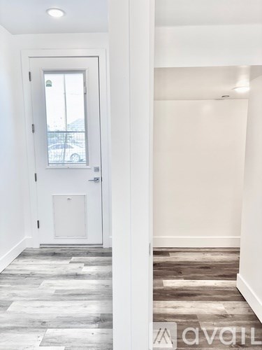 A hallway with a door and a window.