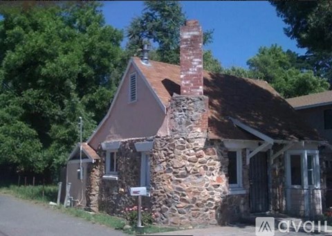 A house with a stone chimney is for sale.