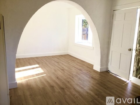 A room with wooden flooring and a white door.