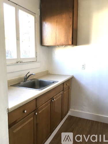 A kitchen with wooden cabinets and a white sink.
