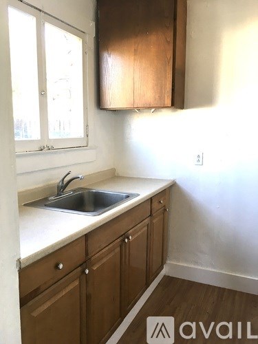 A kitchen with wooden cabinets and a white sink.