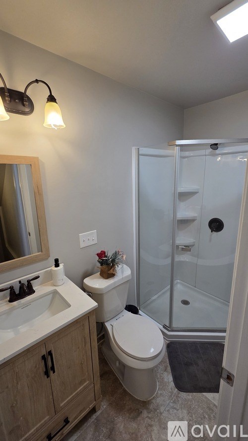 A bedroom with a bed, two chairs, and a ceiling fan.