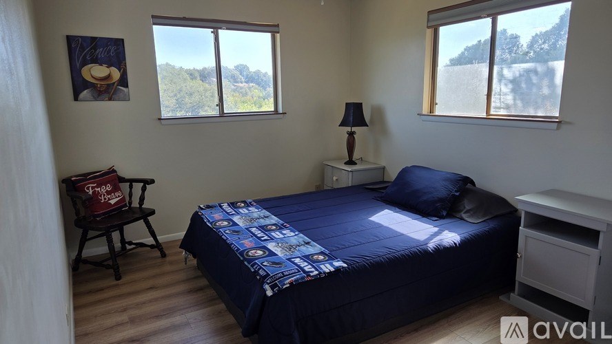 A white closet with a wooden shelf and a white door.