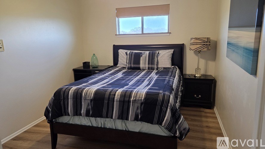A bathroom with a toilet, a shower curtain, and a black mat.