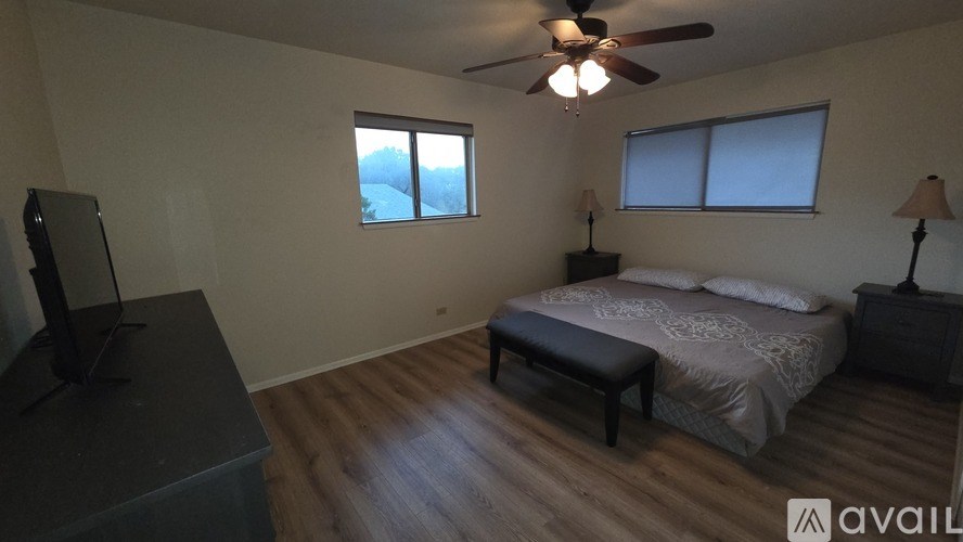 A bedroom with a bed, a bench, and a television.