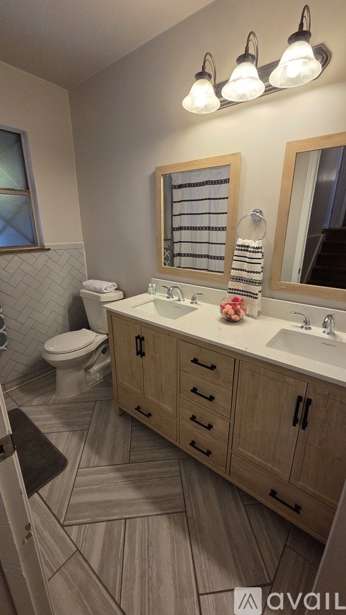 A bathroom with a toilet, sink, and mirror.