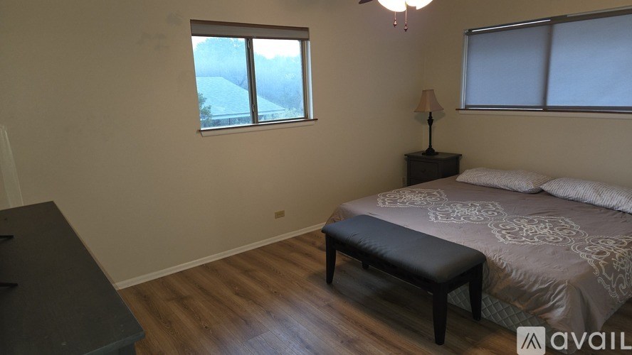 A bedroom with a bed, bench, and window overlooking a snowy landscape.