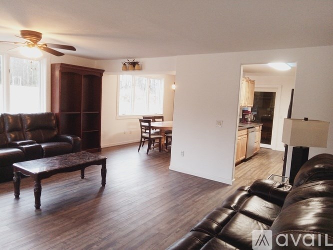 A living room with a brown leather couch and a wooden coffee table.