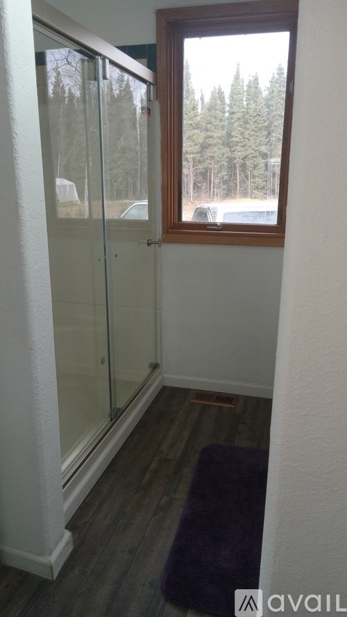 A room with a purple rug and a glass door leading to a balcony.