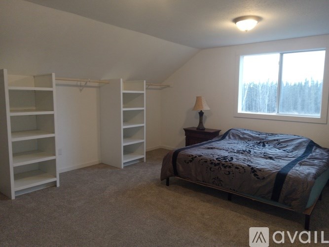 A bedroom with a bed, a dresser, and a window.
