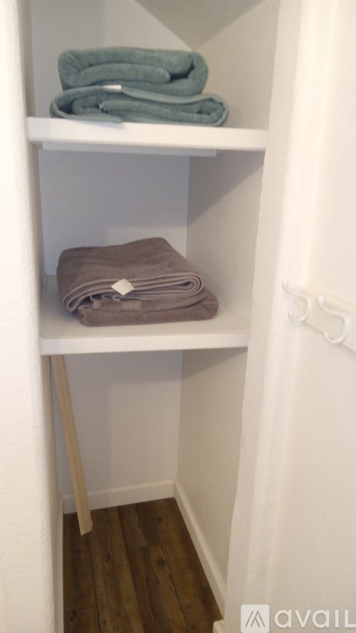 Towels on a shelf in a bathroom.