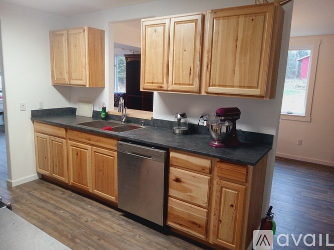 A kitchen with wooden cabinets and a black countertop.