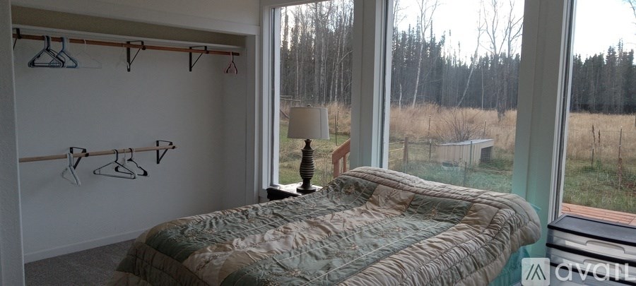 A bedroom with a bed, a window, and a lamp.