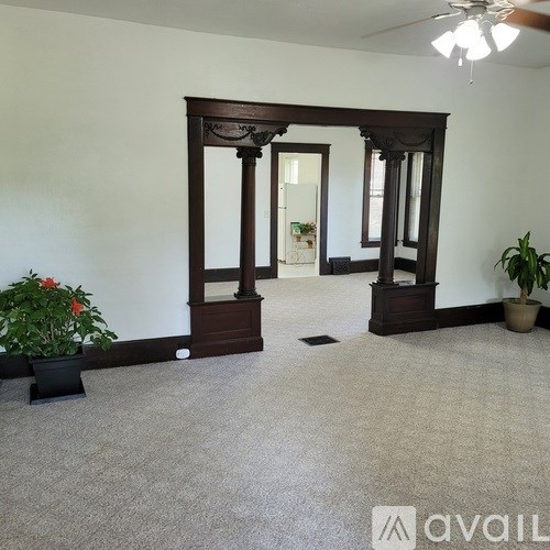 A room with a carpeted floor and a wooden archway.