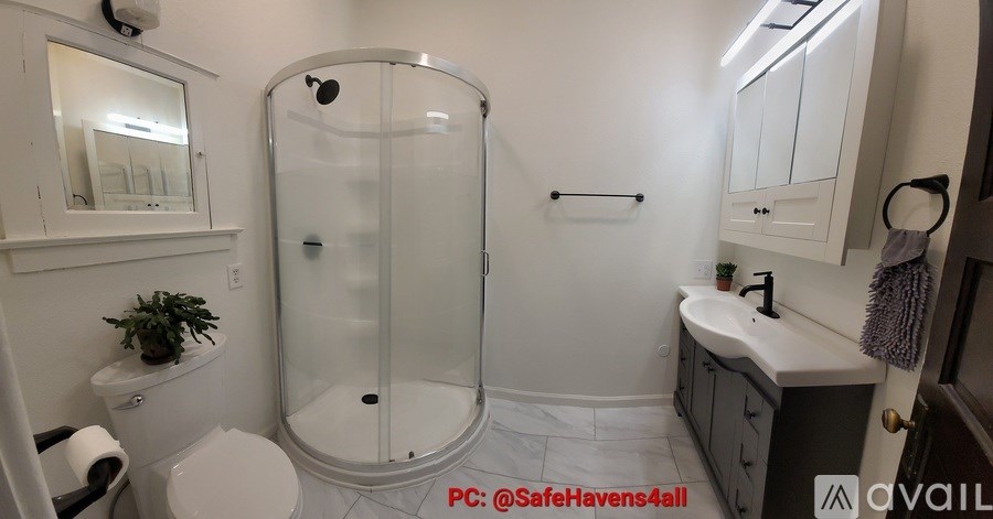 A bathroom with a glass shower door and a white toilet.