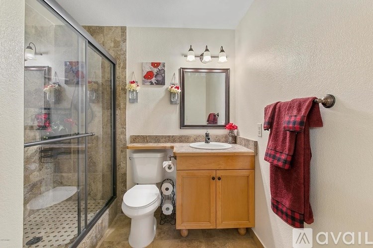 A bathroom with a toilet, sink, and a shower with a glass door.