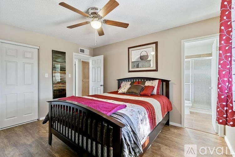 A bedroom with a bed, dresser, and a ceiling fan.