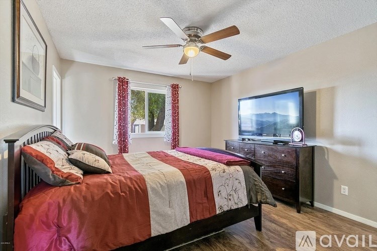 A bedroom with a bed, dresser, and television.