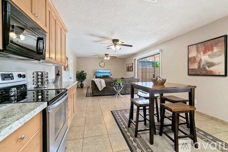 A kitchen with a dining table and chairs in the middle of the room.