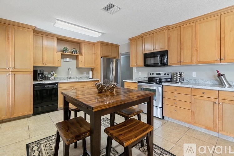 A kitchen with wooden cabinets and a table with two stools.