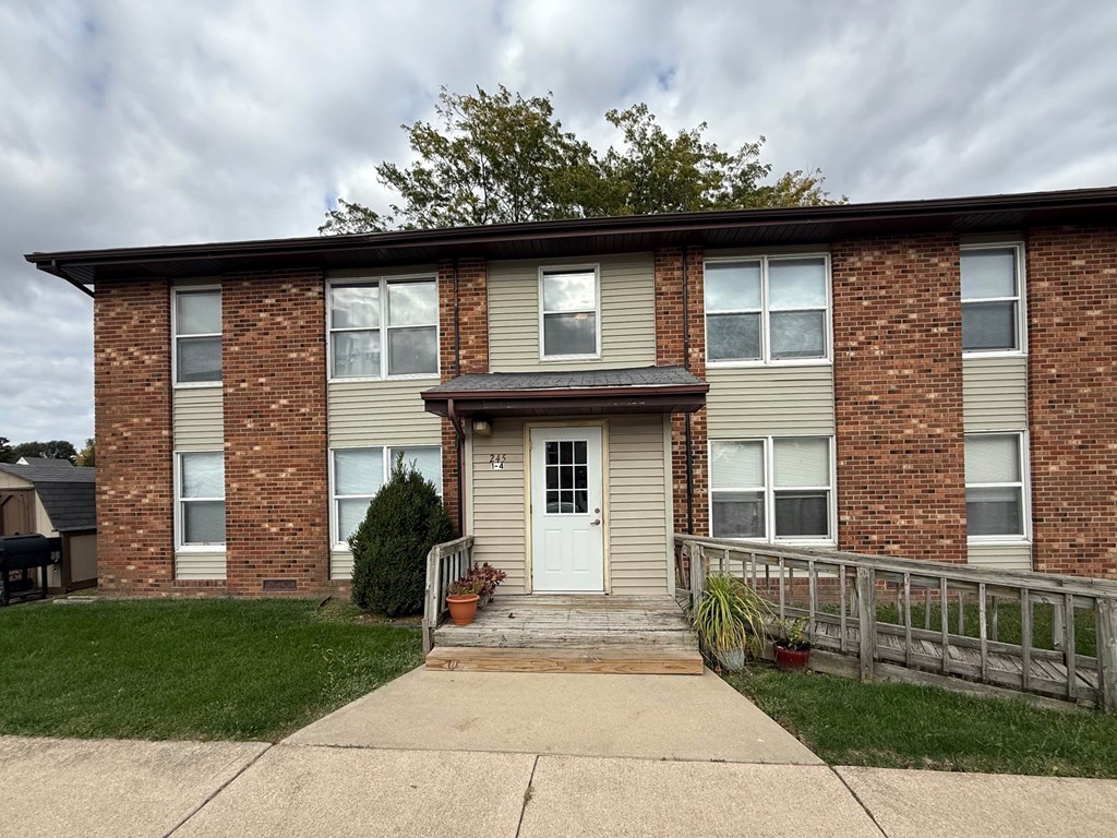 A brick house with a white door and windows.