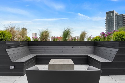 A modern outdoor seating area with a concrete table and benches.