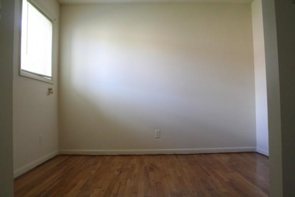 an empty room with a wooden floor and a window