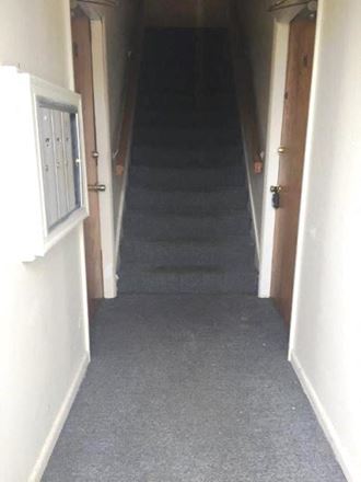 a hallway with stairs going up to a room