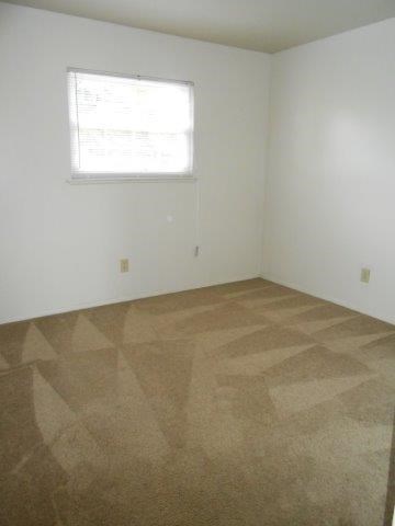 an empty room with a window and a tiled floor