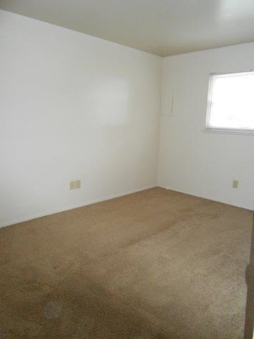 an empty room with a carpeted floor and a window
