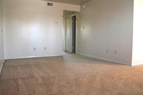 an empty living room with white walls and a door