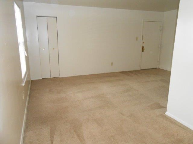 an empty room with a carpeted floor and white walls