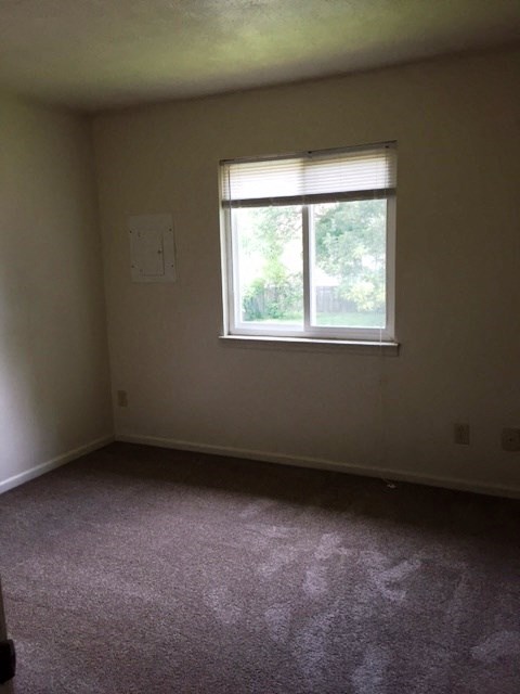 a room with a window and a carpeted floor