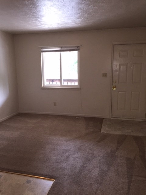 an empty room with a door and a window