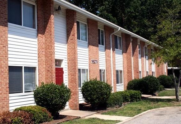 a brick apartment building with a red door