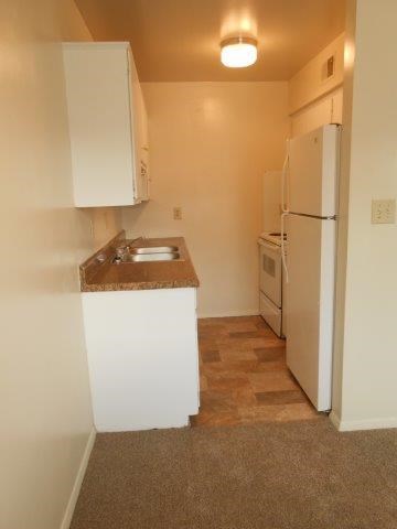 a small kitchen with a sink and a refrigerator