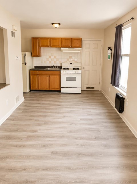 A kitchen with wooden cabinets and a white stove top oven.