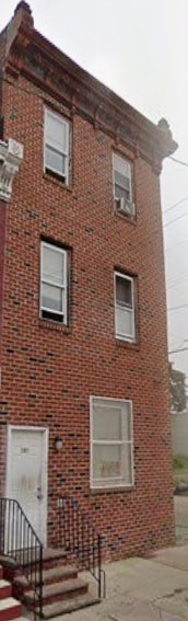 A red brick building with a white door and windows.