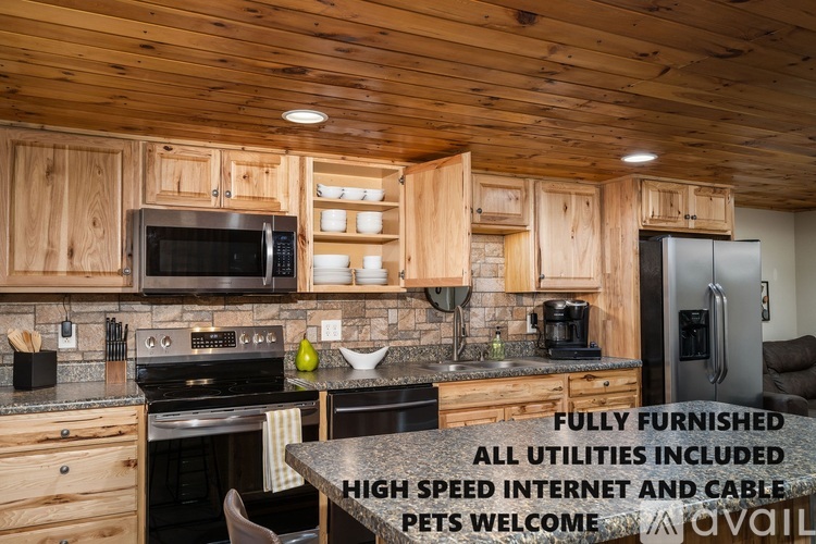 A fully furnished kitchen with a stove, microwave, and refrigerator.